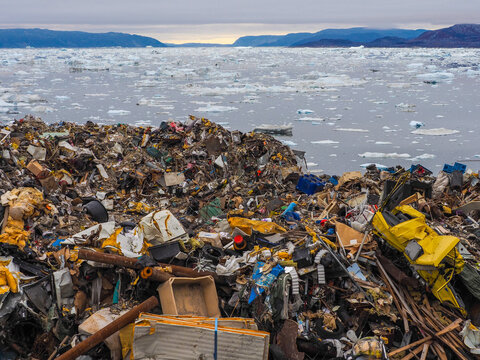 Garbage heap near icy fjord in Arctic region highlighting pollution and environmental impact in remote areas