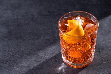 Americano cocktail garnished with twist orange on black slate background. Copy space