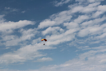 A paraglider flying against the blue sky with white clouds at Zhangye Danxia National Geopark (Rainbow
Mountains) in Gansu, China