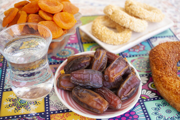 Ramadan background. Delicious iftar. Food on the table: simit, dates, water, dried apricots, cookies