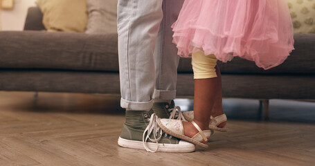 Dance, feet and parent with child in living room of home for bonding, development or learning. Balance, legs and music with father and daughter closeup in apartment for love, teaching or trust