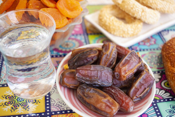 Ramadan background. Delicious iftar. Food on the table: simit, dates, water, dried apricots, cookies
