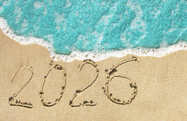 Happy New Year 2026. The number 2026 written on the beach. 