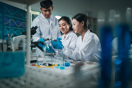 Research team analyzing experiment results with glassware and chemicals in a modern medical laboratory, focusing on scientific collaboration and innovation in biomedical testing