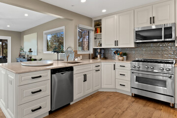 Fototapeta premium A modern kitchen with elegant white cabinets and stainless steel appliances