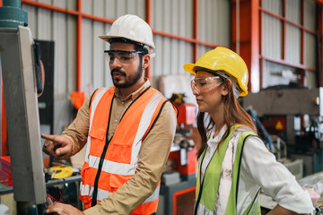 Industrial technicians collaborate in factory, focusing production systems, equipment operation,...