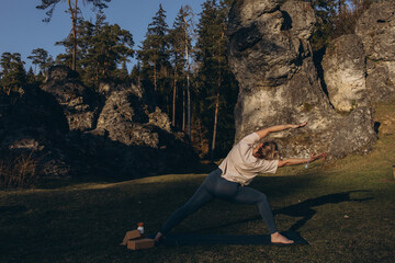 Young woman practicing yoga on nature. Girl meditating outdoors. Female with slim, strength and...