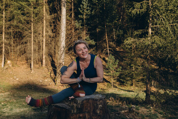 Fit sporty happy young woman wearing sportswear meditating doing yoga breathing stretching...