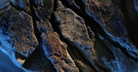 Close-up of cracked stone surface with dramatic blue and orange lighting