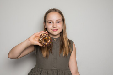 Beautiful child girl holding testy donut. Cute little girl with sweet food indoor