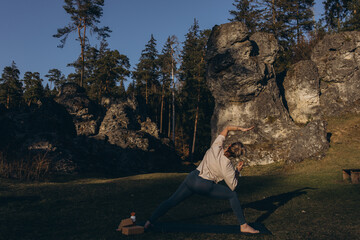 Young woman practicing yoga on nature. Girl meditating outdoors. Female with slim, strength and...