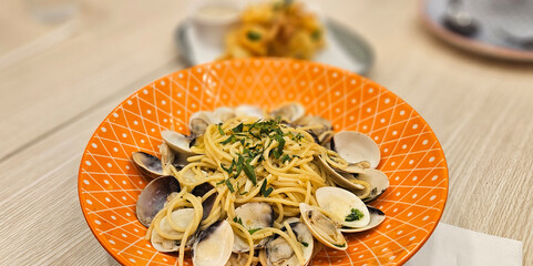 Spaghetti vongole spaghetti with clams & mussels serving on yellow plate