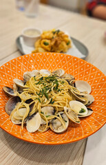 Spaghetti vongole spaghetti with clams & mussels serving on yellow plate