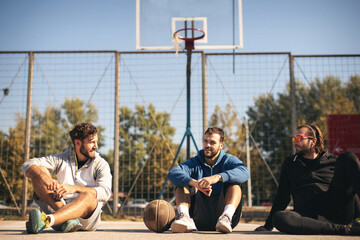 Group of friends playing basketball outdoors.
