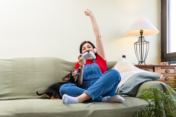 Woman and her dog celebrating victory together by winning playing a video game