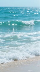 Waves crashing on a sandy beach with clear blue sky