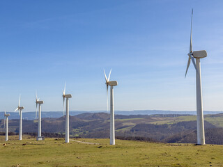wind power plants against a blue sky on a bright sunny day