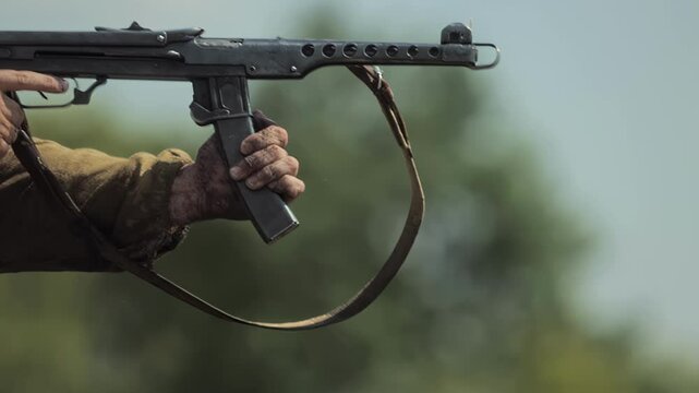 Red Army soldier shoots from Soviet PPS-43 submachine gun during simulated fight offensive, slow motion 8x. Historical reenactment of Great Patriotic War battle in USSR. World War II Eastern Front