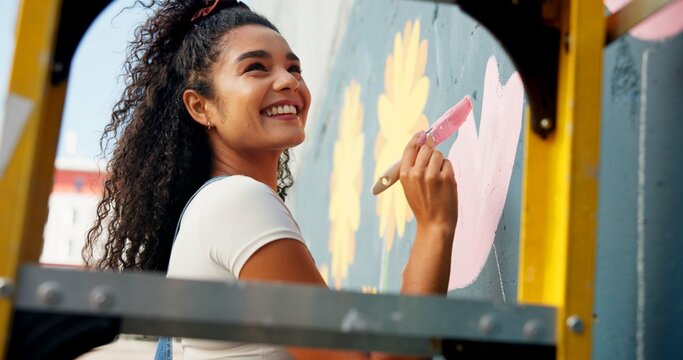 Happy, mural and woman painting wall for art design, creative project and community service. Artist, volunteer and person with paintbrush outdoor for flower decor, inspiration and DIY hobby in city