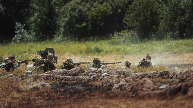 World War Two historical military reenactment event Red Army soldiers in trench shoot with rifle, Soviet sniper, heavy Maxim machine gun near. Troops defend from German infantry offensive. Summer 1944