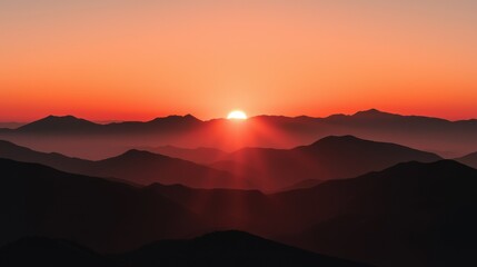 Obraz premium A vibrant sunset illuminates layers of mountain silhouettes in the sky
