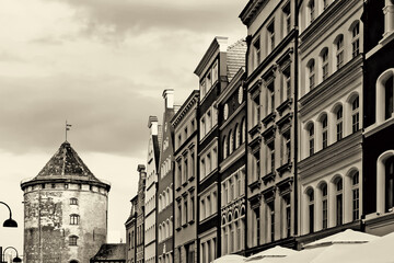 Sepia getöntes Bild der Fassaden historischer Häuser und des Milchkannentors in der Altstadt von Danzig, Polen