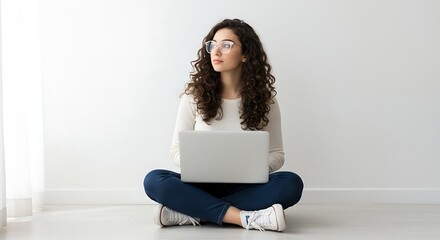 Young Woman with Curly Hair Using Laptop While Sitting on Floor