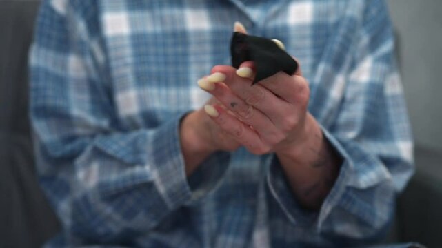 Girl in blue shirt wipes her hands with wet wipe.
Antibacterial wipes in female hands.
Skin health and hygiene.
Clean skin.
Healthy skin without germs.
Antibacterial saphlenta