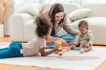 Fototapeta premium Happy Mother Playing with Daughters at Home.