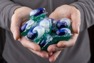 washing laundry capsules in hands. Capsule for washing in the washing machine