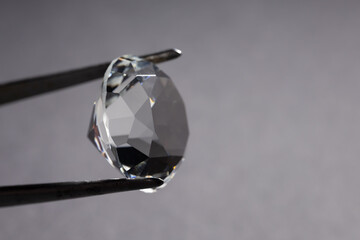 Tweezers with beautiful shiny diamonds on dark closeup