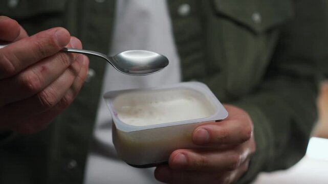 Close-up of a curd yogurt in a guy's hands.
A man stirs cream with a spoon.
Sweet curd in a glass.
Berry yogurt.
A man with food in the kitchen