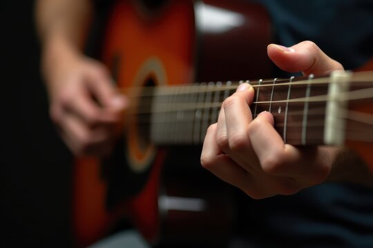 Playing guitar close-up in dimly lit room