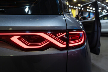 Modern car taillight design showcased at an auto exhibition in the evening