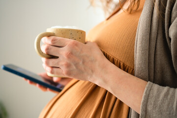 Glowing expecting mother enjoying coffee break at home. Educated perspective on caffeine limits for...