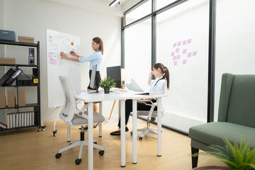 In a contemporary office, two young woman entrepreneurs are on a mission to generate ideas