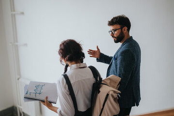 Two students engage with their professor in a hallway, discussing academic charts. The scene...