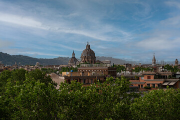 A scenic view over Rome highlighting its iconic dome architecture and urban structure, nestled against a backdrop of greenery