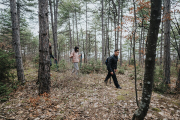 Obraz premium Friends enjoying a hike through a serene forest on a cool, cloudy day surrounded by trees and nature, creating a vibrant connection with the outdoors and fostering memorable experiences together.