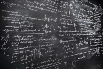 Intricate mathematical equations densely cover a dark chalkboard, a testament to complex problem-solving and academic pursuit.