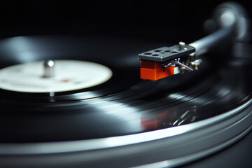 Close up of a spinning vinyl record on a turntable with focus on the needle and grooves