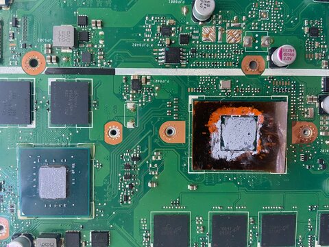 Close-up of a computer motherboard with exposed processor and thermal paste, showing detailed electronic components and circuit layout - Powered by Adobe