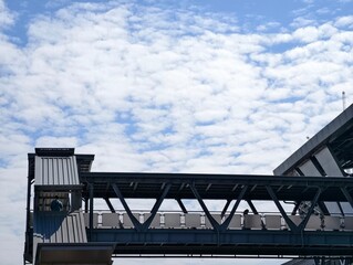 Fototapeta premium Modern Walkway Under Blue Sky with Clouds