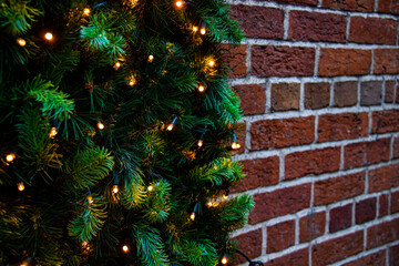 Horizontal close-up shot of brick wall with garlands. Christmas background