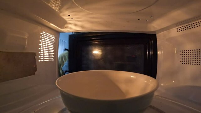 Man taking a bowl out of the microwave. Microwave concept. Bowl concept.