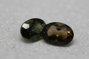 Close-Up View of Two Brilliant Cut Gemstones on Soft Gray Surface