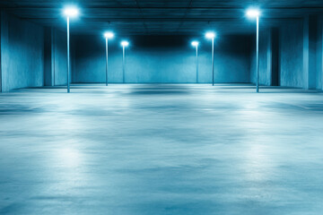Empty underground parking garage with blue lighting and symmetrical pillars in low light setting