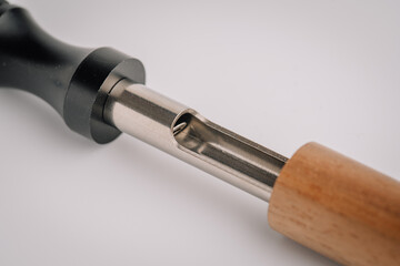 Close-up of a partially disassembled vape device showing the inner metal chamber between a black...