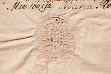 Detailed shot highlighting the embossed design and aged texture of a historical document authenticated with a dry seal.