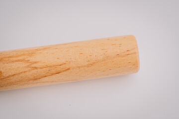 Close-up of a smooth, cylindrical wooden stick on a white background with visible natural wood grain and copy space..